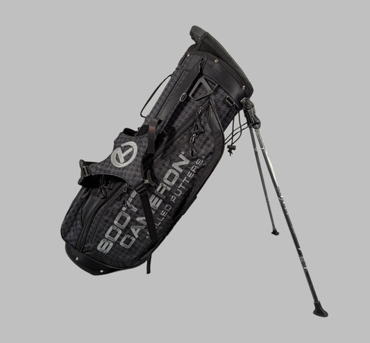 Black golf bag with stand on a gray background