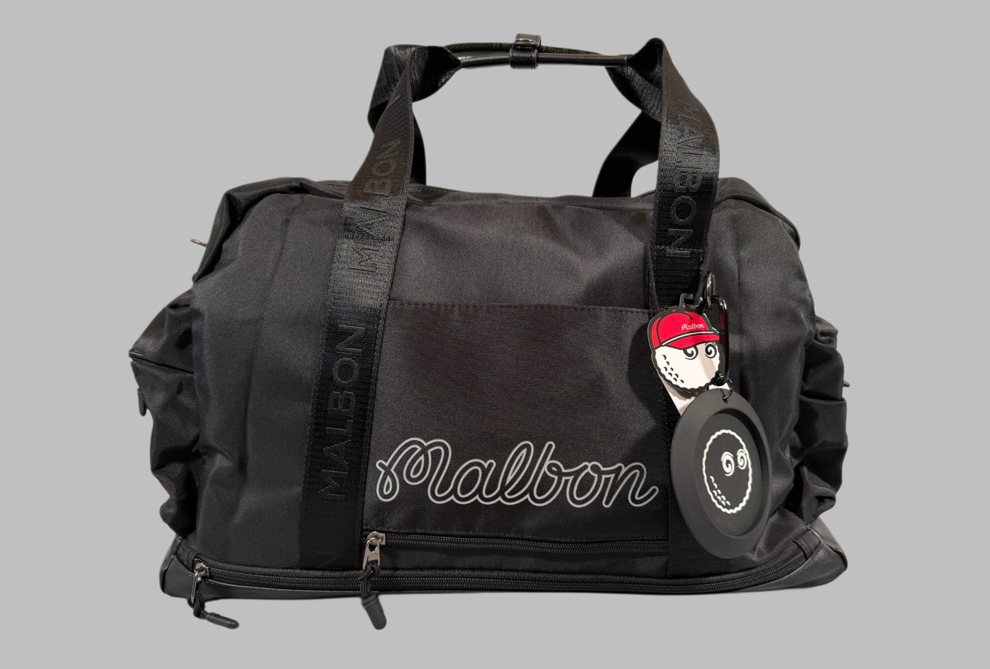 Black duffel bag with 'Malbon' branding on a gray background