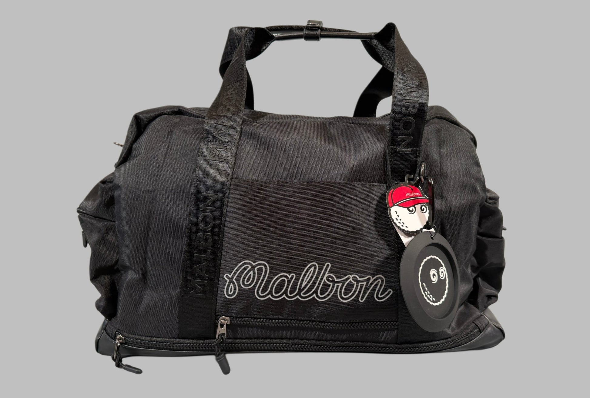 Black duffel bag with 'Malbon' branding on a gray background