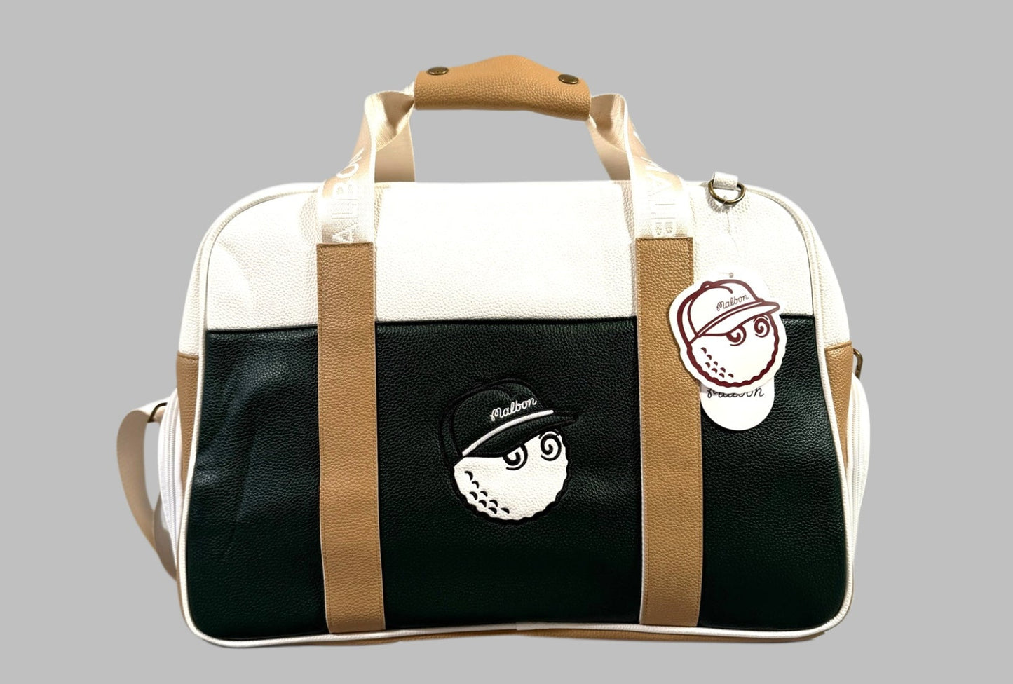 White and black duffel bag with brown straps on a gray background